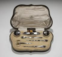 A pique ware manicure set in a leather case. English, 1913
