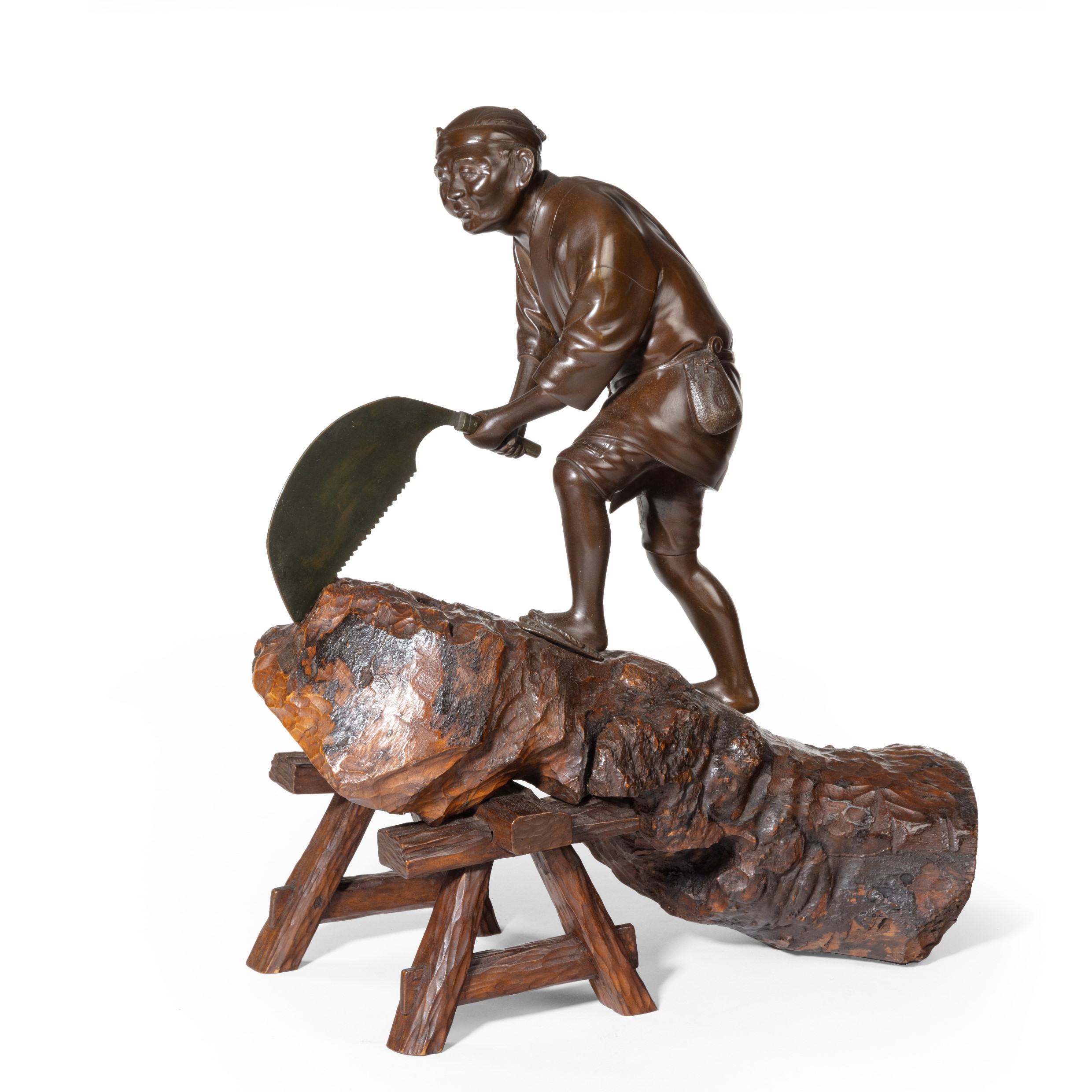 An attractive Meiji period bronze of a woodcutter sawing a large tree trunk