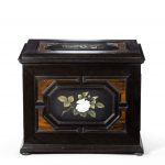 A fine quality ebony bijouterie table cabinet showing Cavalry Church, Stonington, Long Island white flower front