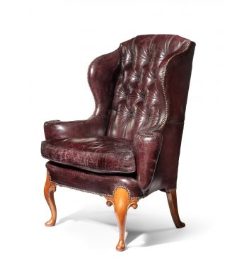 A large George I style burgundy leather wing arm chair