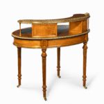 An unusual Victorian freestanding oval satinwood desk back left