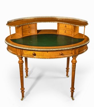 An unusual Victorian freestanding oval satinwood desk