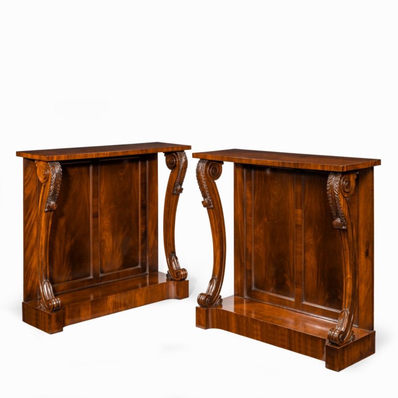 A pair of late Regency flame mahogany console tables