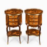 A pair of French rosewood occasional tables, each of oval form with three small drawers set upon cabriole legs joined by a kidney-shaped shelf, decorated in boxwood and kingwood marquetry with oriental landscapes showing a courtly boat on a lake between two pagodas and further landscapes on the sides, back and shelf