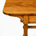 A late Regency rosewood end support table Gillows or Holland and Sons, the rounded rectangular top set above a frieze with two drawers on one side and dummy drawers on the other, the solid end supports