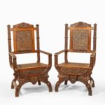 A pair of Indian throne chairs, carved with the arms of the Kingdom of Travancore