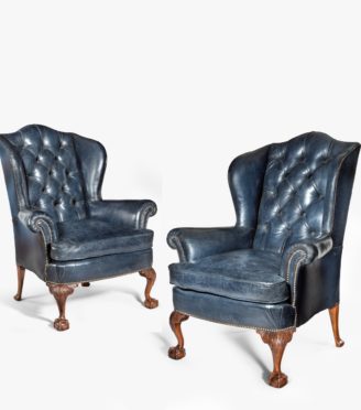 A pair of Chippendale style leather wing armchairs