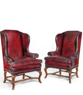 A pair of George I style walnut wing arm chairs