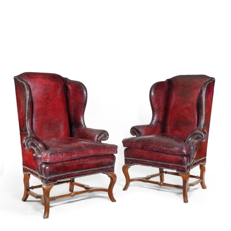 A pair of George I style walnut wing arm chairs