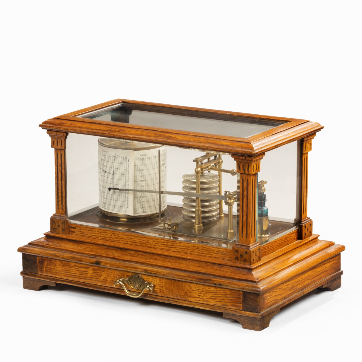 An Edwardian cased oak barograph with bevelled glass panels and a central chart drawer.