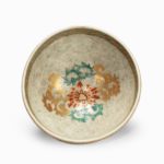 A small Satsuma earthenware tea bowl, the speckled greyish body decorated with four panels of alternating bijin and flowers, painted in overglaze enamels and gilt. Japanese