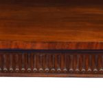 A large Regency mahogany serving table attributed to Gillows, the shaped top above a fluted frieze with four superb ormolu lion’s mask roundels, all raised on six slender, tapering reeded legs with ormolu ball feet detail