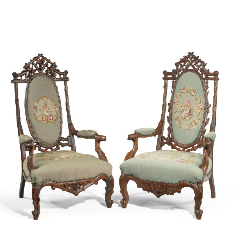 A pair of ‘Black Forest’ linden wood arm chairs