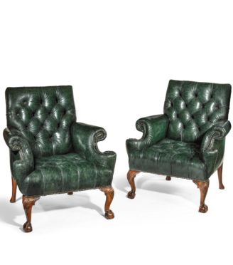 A pair of George II style walnut wing arm chairs