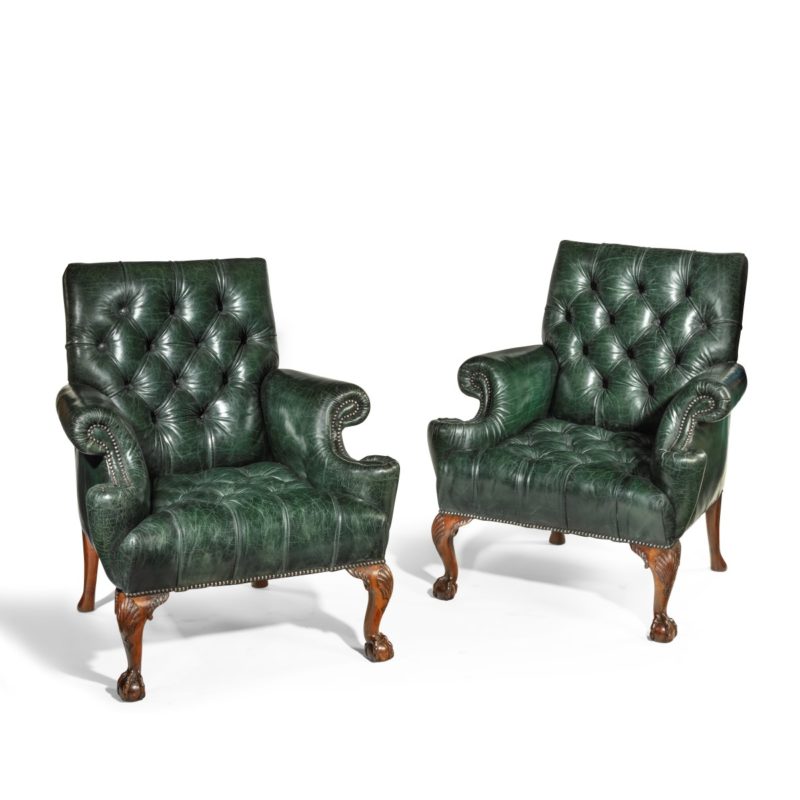 A pair of George II style walnut wing arm chairs