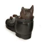 A Black Forest fruitwood carving of a cat in a boot back