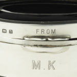 A small lobed oval tortoiseshell piqué patch pot by Mappin and Webb, the hinged lid with a plain silver oval, incised ‘From M.K.’, raised on four small feet. English, assay marks