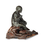 A Meiji period bronze of a seated man smoking