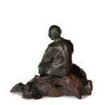 A Meiji period bronze of a seated man smoking back
