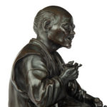 A Meiji period bronze of a seated man smoking detail