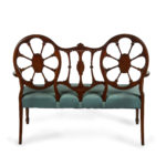 A late Victorian satinwood wheel back settee in the Chippendale style, attributed to Wright and Mansfield back