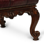 An early Victorian leather-upholstered rosewood stool leg