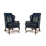 A pair of walnut Georgian style leather wing armchair