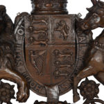 A Victorian carved oak Royal Coat of Arms, the central shield quartered with the three lions England, an Irish harp and a lion rampant surmounted by a crown and supported by the lion and unicorn, with the flowers of the union and motto ‘Dieu et Mon Droit’beneath