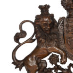 A Victorian carved oak Royal Coat of Arms, the central shield quartered with the three lions England, an Irish harp and a lion rampant surmounted by a crown and supported by the lion and unicorn, with the flowers of the union and motto ‘Dieu et Mon Droit’beneath details