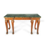 A late Victorian pitch pine console table after Linnell, the rectangular top set upon a frieze carved with Vitruvian scrolls and surmounted by a painted faux marble top, all raised upon six powerful cabriole scroll legs carved with acanthus leaves on the knees above scale pattern panels. English, circa 1900.