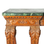 A late Victorian pitch pine console table after Linnell, the rectangular top set upon a frieze carved with Vitruvian scrolls and surmounted by a painted faux marble top, all raised upon six powerful cabriole scroll legs carved with acanthus leaves on the knees above scale pattern panels corner