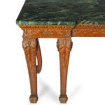 A late Victorian pitch pine console table after Linnell, the rectangular top set upon a frieze carved with Vitruvian scrolls and surmounted by a painted faux marble top, all raised upon six powerful cabriole scroll legs carved with acanthus leaves on the knees above scale pattern panels corner